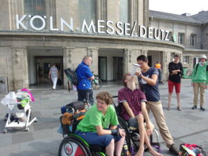 Rollstuhlfahrer spricht ins Megafon, eine andere Person hält das Megafon