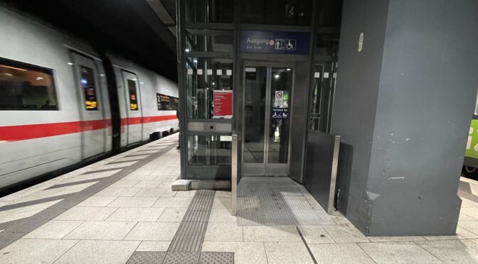 Aufzug auf Gleis 13 am Hamburger Hauptbahnhof. Eingang durch Rampe und Wände rechts und Links verengt, Blindenleitsystem führt neben der Rampe gegen die Wand zum Aufzug-Rufknopf